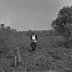 Estella Leopold in garden carrying onions