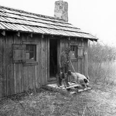 Aldo Leopold with dogs at Missouri cabin