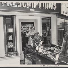 Man shovels flood debris out of a drugstore