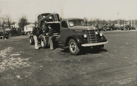 A tow truck loaded with a Nash automobile