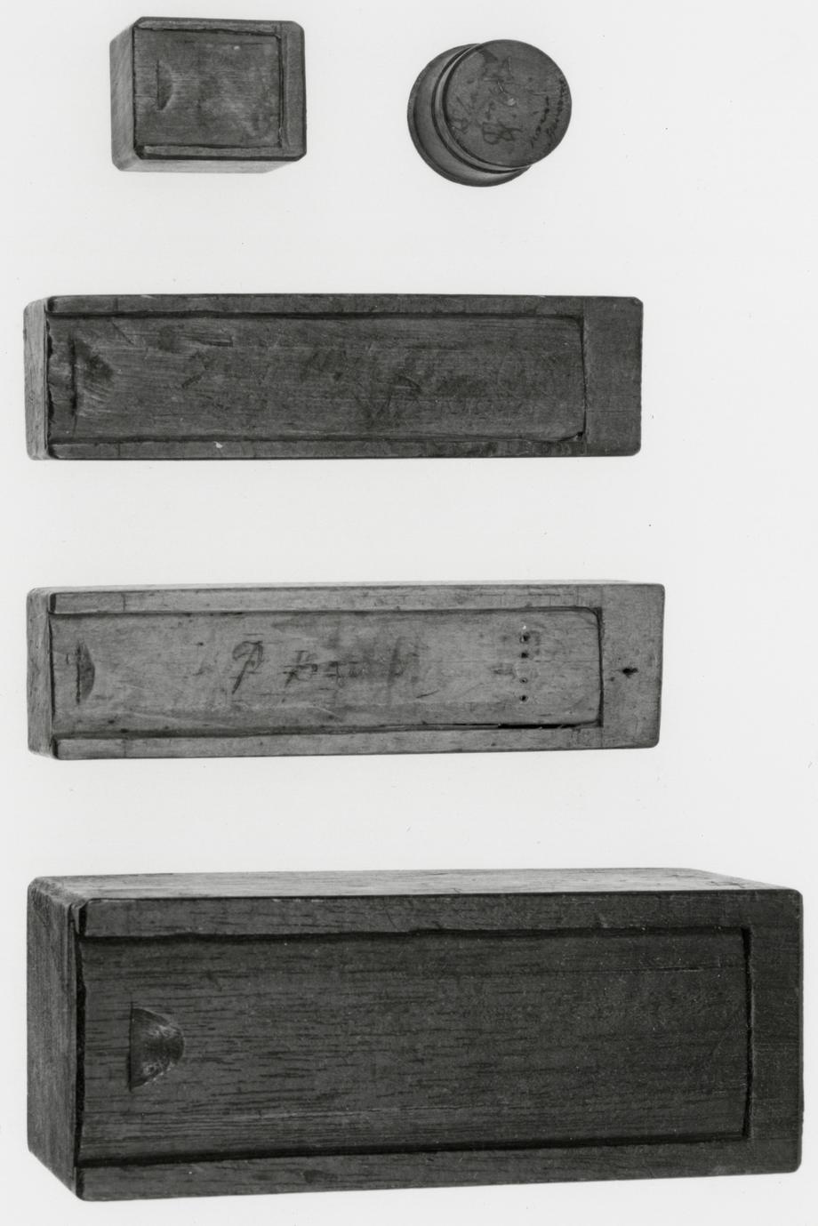 Black and white photograph of various boxes inscribed with their specific contents.