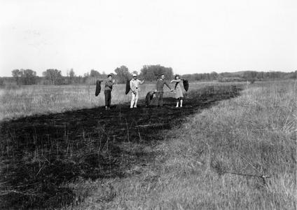 Aldo with group participating in controlled prairie burn, UW Arboretum, middle 1940s (AL 2nd from L, in white)