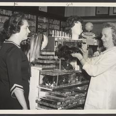 A saleswoman helps a customer select a wig