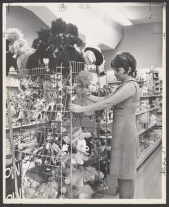 A young woman views stuffed animals in a toy display