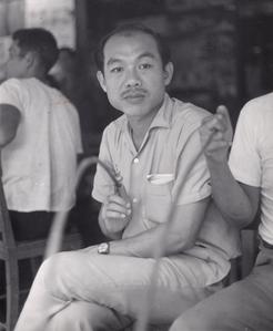 Mr. Autit is seated with villagers in Houei Kong