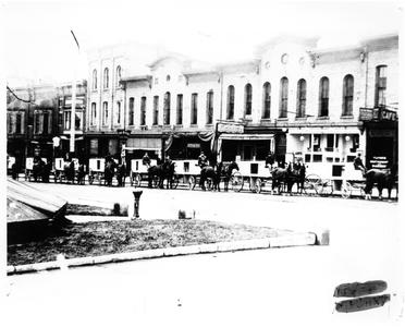 Horses and wagons lined up on Milwaukee Street