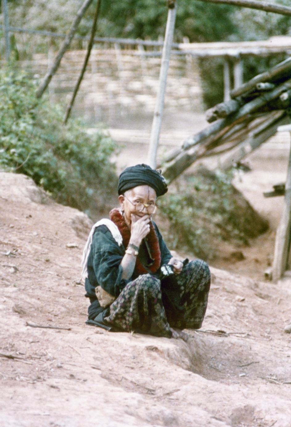 A Yao (Iu Mien) woman is seated and embroidering in Houa Khong Province