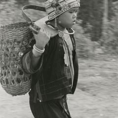 Young Akha girl carries vegetables from the family garden to the village of Phate in Houa Khong Province