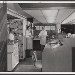 Pharmacists work behind the prescription counter of a drugstore