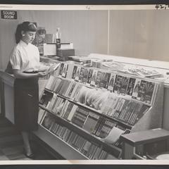 Young woman stands next to a drugstore's music department