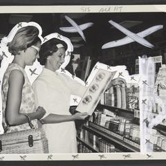 Two women look at a brochure in a drugstore