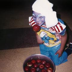 Boy in costume bobbing for apples
