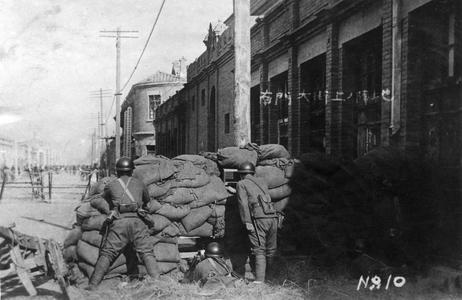 Japanese soldiers in position on the street outside the South Gate.