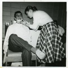 Sigma Tau Gamma - female student shaving the face of a male student