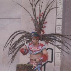 Man drumming in traditional dance costume on Library Mall
