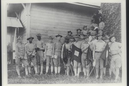 Black and white U.S. troops with signal corps flag, 1899-1902