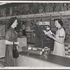 A woman stands at a drugstore checkout counter