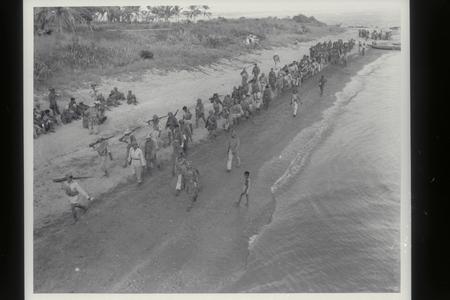 Guerrillas march on beach to LCI, Masbate, 1945