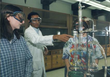 Chemistry professor assists two students in lab