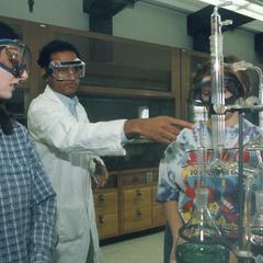 Chemistry professor assists two students in lab