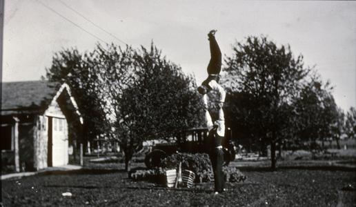 Walter Karwatka performs handstand as Max Peters supports him