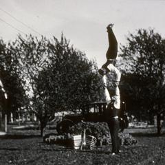 Walter Karwatka performs handstand as Max Peters supports him