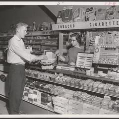 A saleswoman assists a shopper at the tobacco counter
