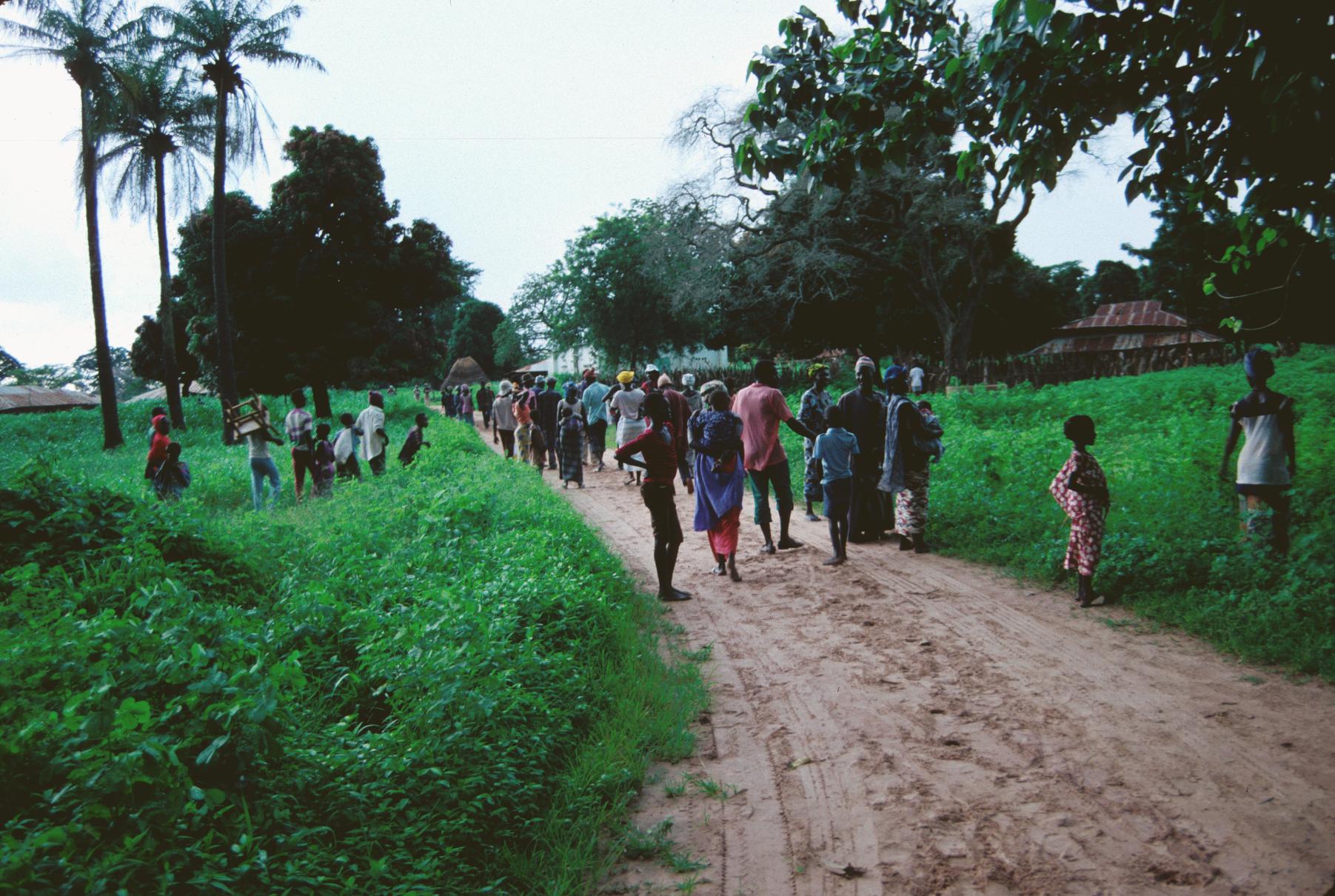 Country Road with Many Gambians Walking on It