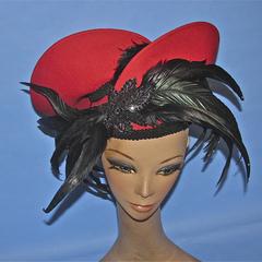 Red felt hat with black feathers