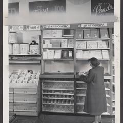 A shopper tests out a pen at a drugstore stationery display