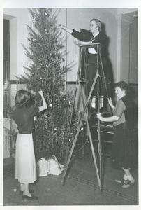 Young Women's Christian Association members decorating Christmas trees in front of the Harvey Memorial