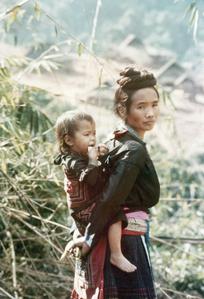 A Blue Hmong (Hmong Njua) mother carries her child on her back in Houa Khong Province
