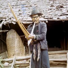 Man playing the "qeej" in a northern Blue Hmong village in Thailand