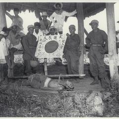 Guerrillas with dead Japanese, 1945