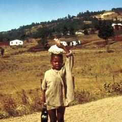 Little Girl Carrying Coke Bottle in Non-White Area