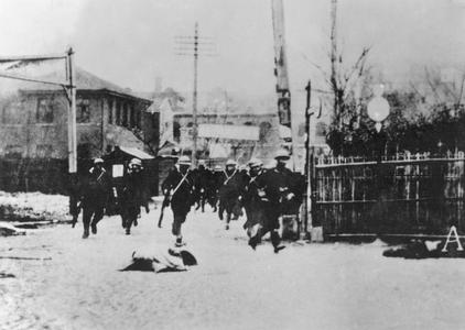 Japanese marines hurrying through a silent street.