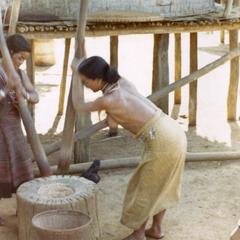 Two Nyaheun women are pounding rice in a village in Attapu Province