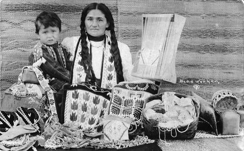 Ojibwa woman and child pose with beadwork and mats