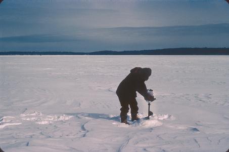 John J. Magnuson drilling hole for sampling under ice