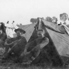 Soldiers of the US Army's 15th Infantry Regiment squatting in front of their tents.