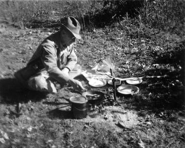 Aldo Leopold cooking breakfast at campsite