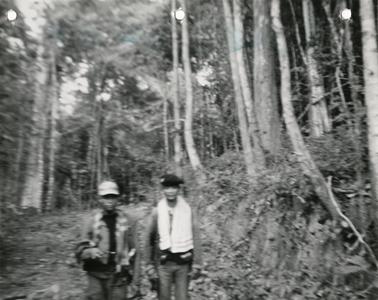 Two soldiers walk along portion of Route 11 between the villages of Ban Phone and Ban Sok