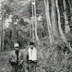 Two soldiers walk along portion of Route 11 between the villages of Ban Phone and Ban Sok