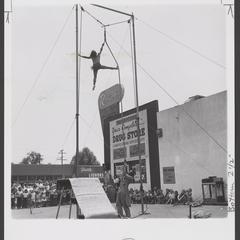An acrobat performs in front of a drugstore