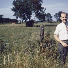 Chancellor Edward W. Weidner standing in field on future campus site