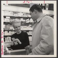 A salesclerk assists a shopper at the cosmetics counter