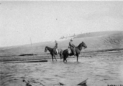 Postcard of men on horseback in river in Southwest