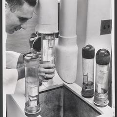 Man inserts a canister of medicine into pneumatic tube