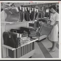 A shopper examines a brief case from a drugstore display