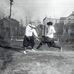 Two women play baseball
